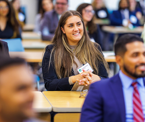 A classroom full of students sitting and smiling